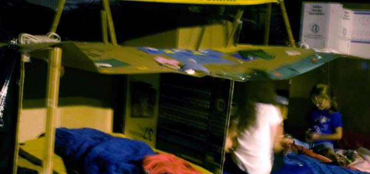 image of homeless cardboard home as an art project with sleeping bags and a sign over it reading Boy Scouts of America